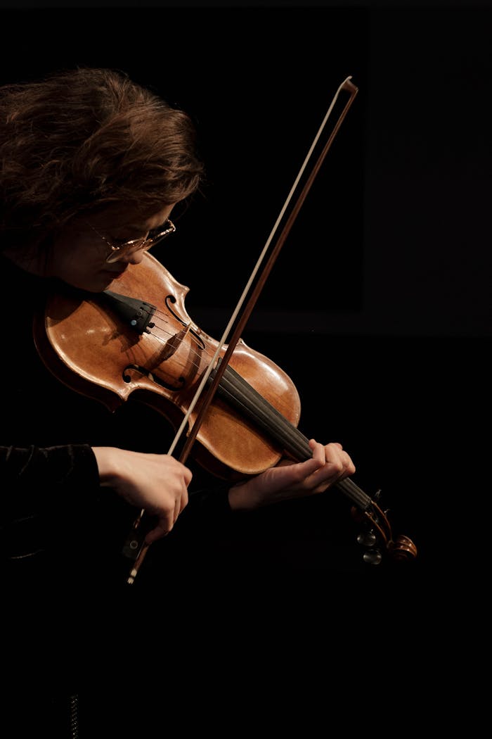 Home A professional violinist performing passionately under soft lighting, creating an elegant musical ambiance.